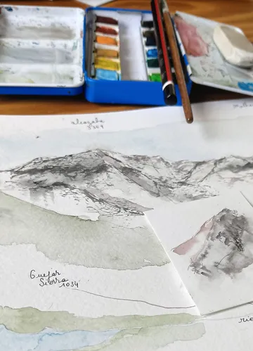 Apuntes en acuarela de los picos de Sierra Nevada junto a una caja de acuarelas
