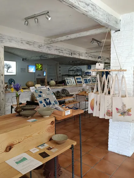 Mesas de madera con cerámica, imanes de cianotipia y bolsas de tela ilustradas
