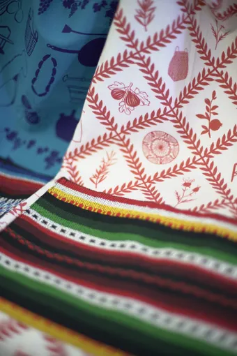 Telas estampadas a mano con motivos botánicos en rojo y azul y tejidos de rayas de colores